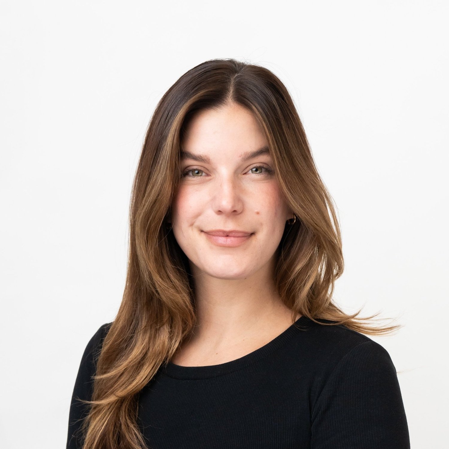 Portrait of a woman with long brown hair wearing a black shirt, smiling slightly against a plain white background.