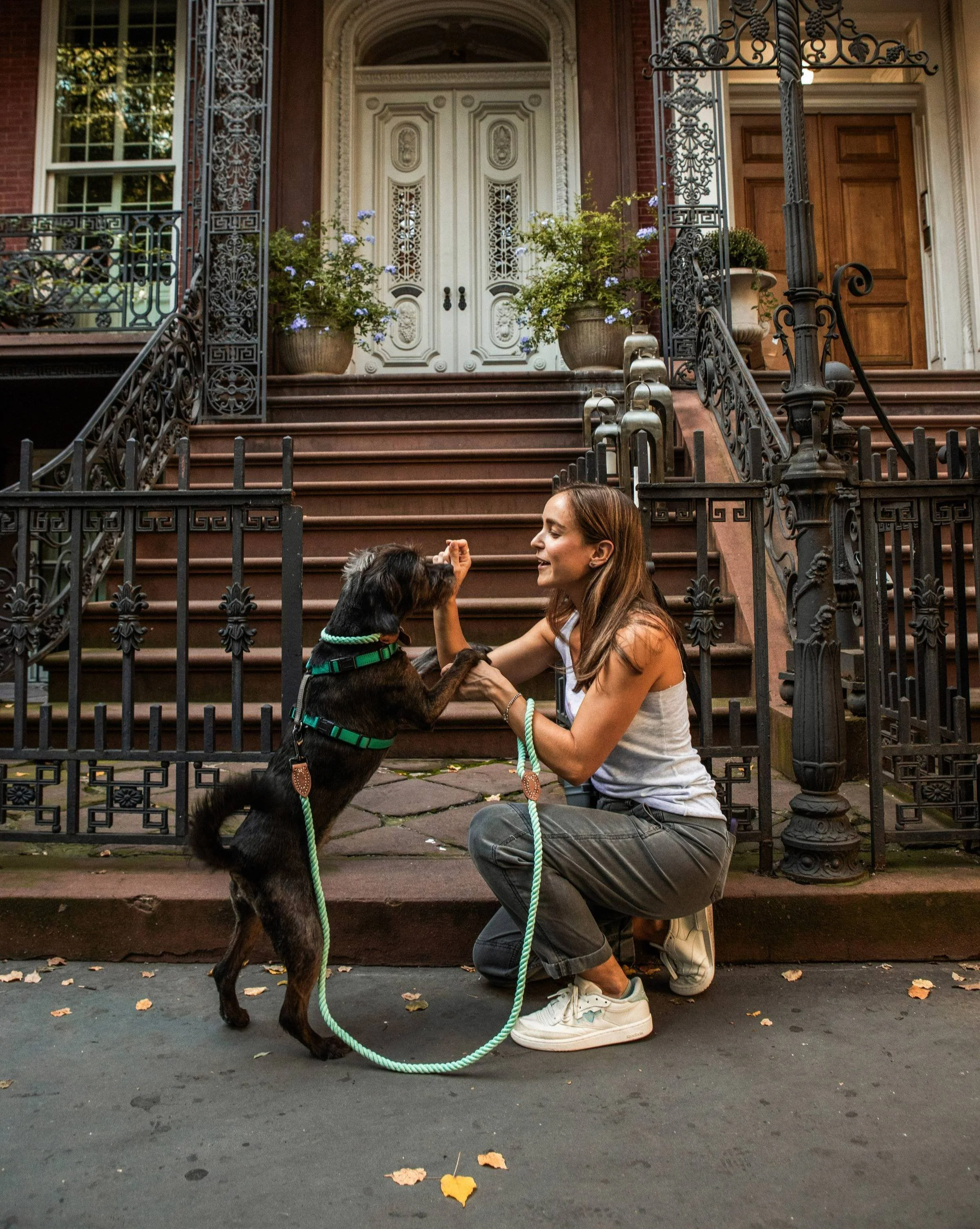 Maddie kneeling and rewarding dog standing on hind legs