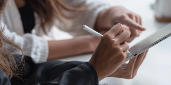 Two women are working together on a tablet to make the transition process smooth