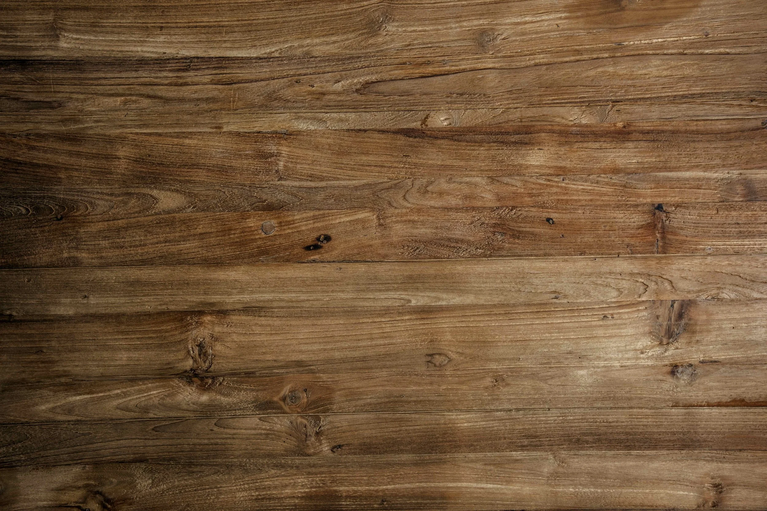 A close-up view of wooden floorboards with visible wood grain and knots.