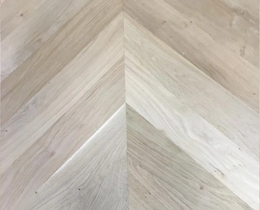 Close-up of a light-colored wooden chevron-patterned floor.