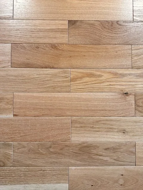 Close-up of a wooden hardwood floor with horizontal planks varying in natural wood tones.