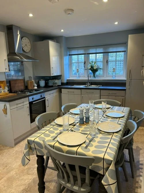 Large kitchen area with a table and 6 chairs around.