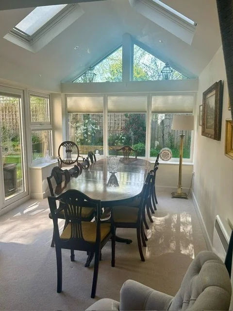 View of the dining area, includes a table with 4 chairs and doors leading out to a garden.