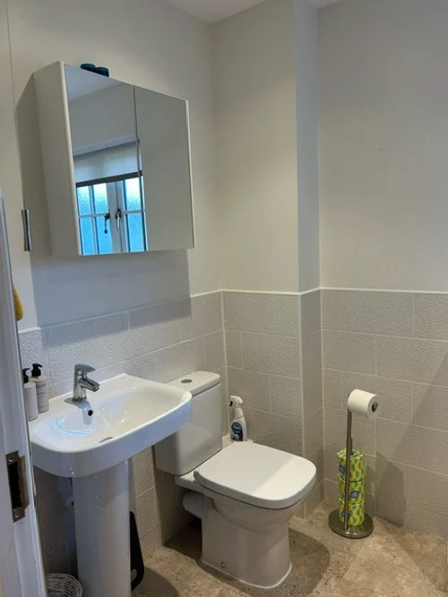 View of a white bathroom with  sink and toilet.
