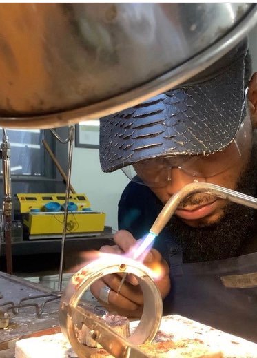 The founder of DREAM NYC working with a torch at the jeweler’s bench