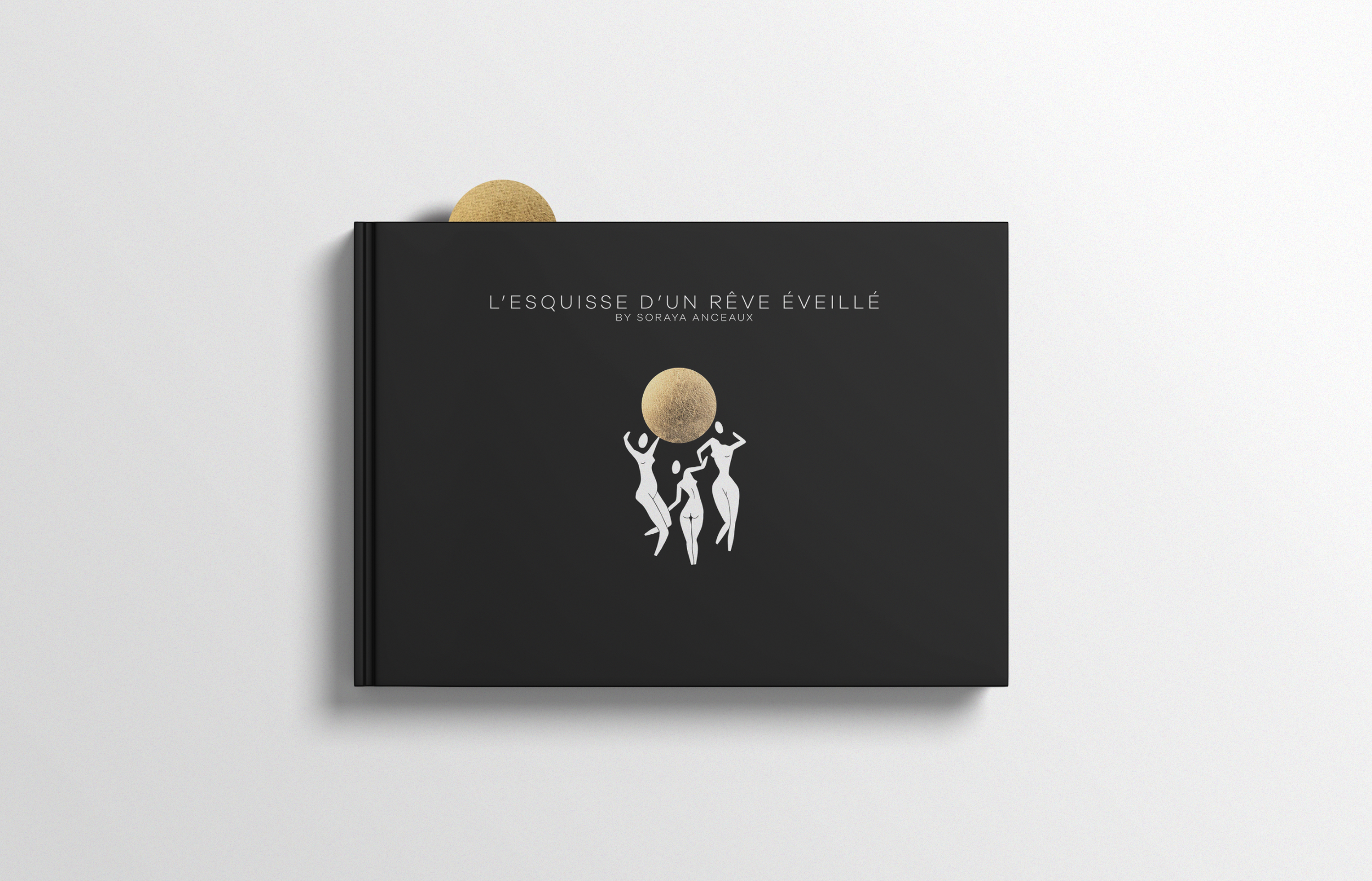 Black book with white abstract figures and gold circle on cover, titled 'L'Esquisse d'un Rêve Éveillé' by Soraya Anceaux