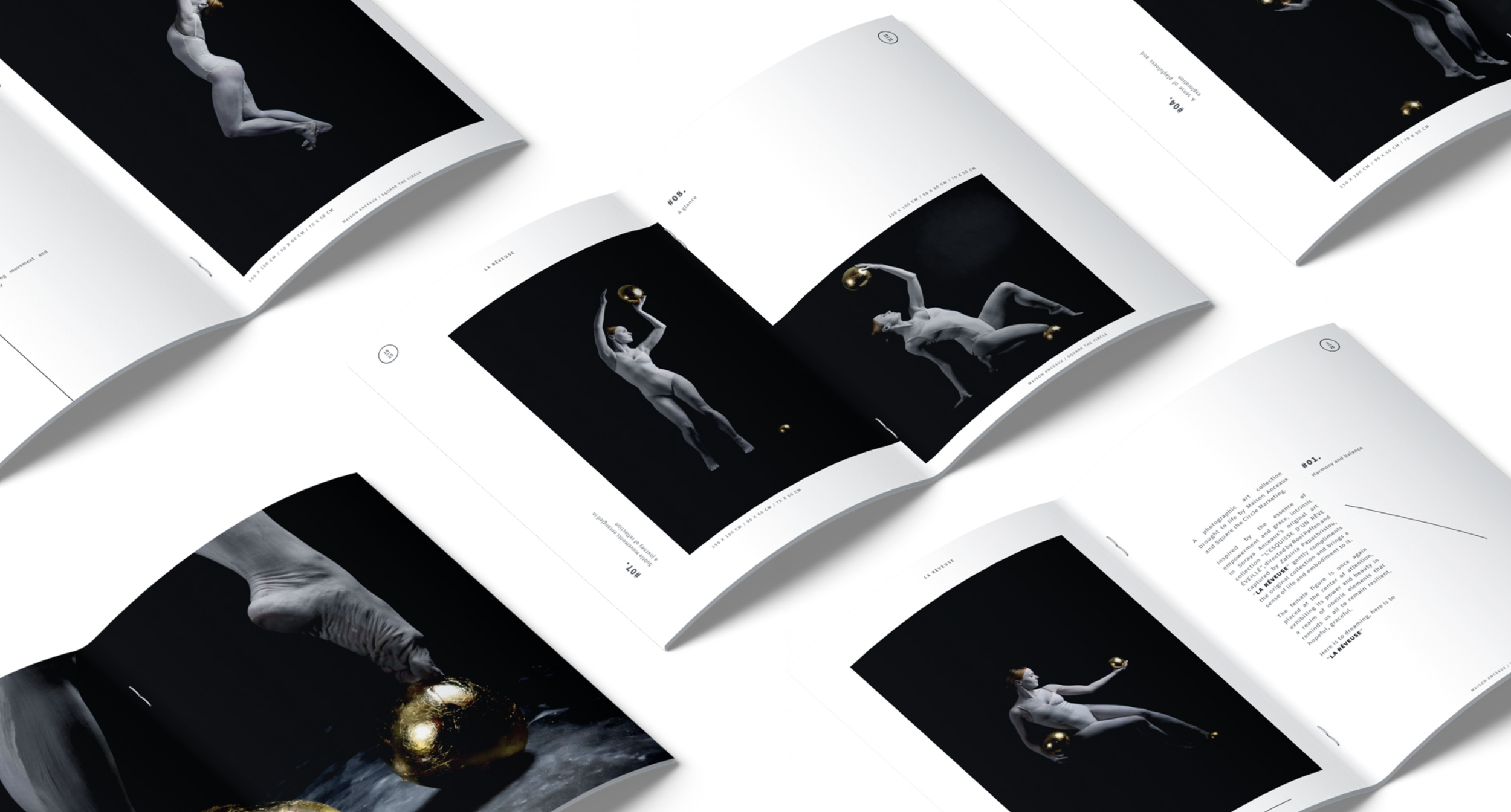 Open magazines displaying minimalist black-and-white artistic photos of a dancer with gold objects, arranged on a white surface.