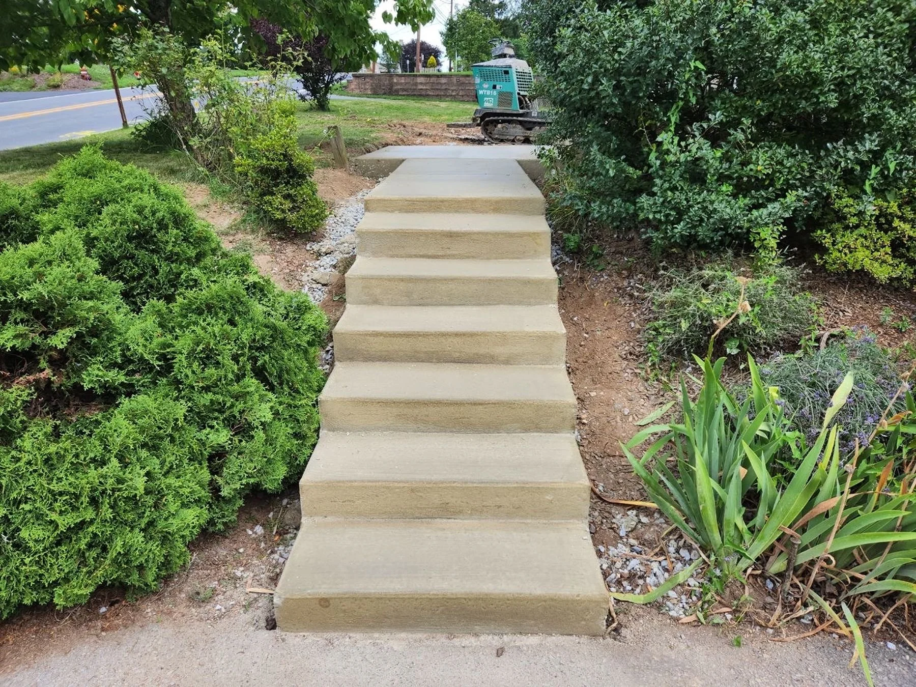 Concrete landscape steps installation with clean grading and planting beds in Harrisburg Pennsylvania