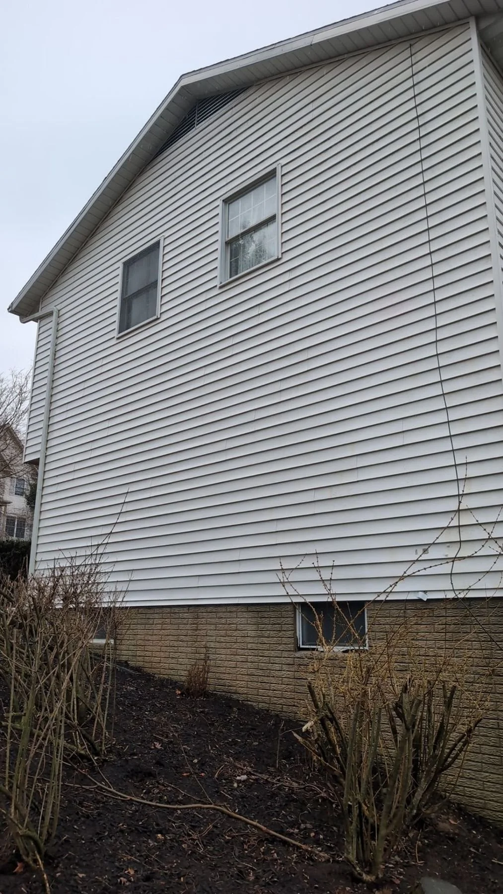 Clean white house siding after professional power washing removing dirt and algae in Central PA