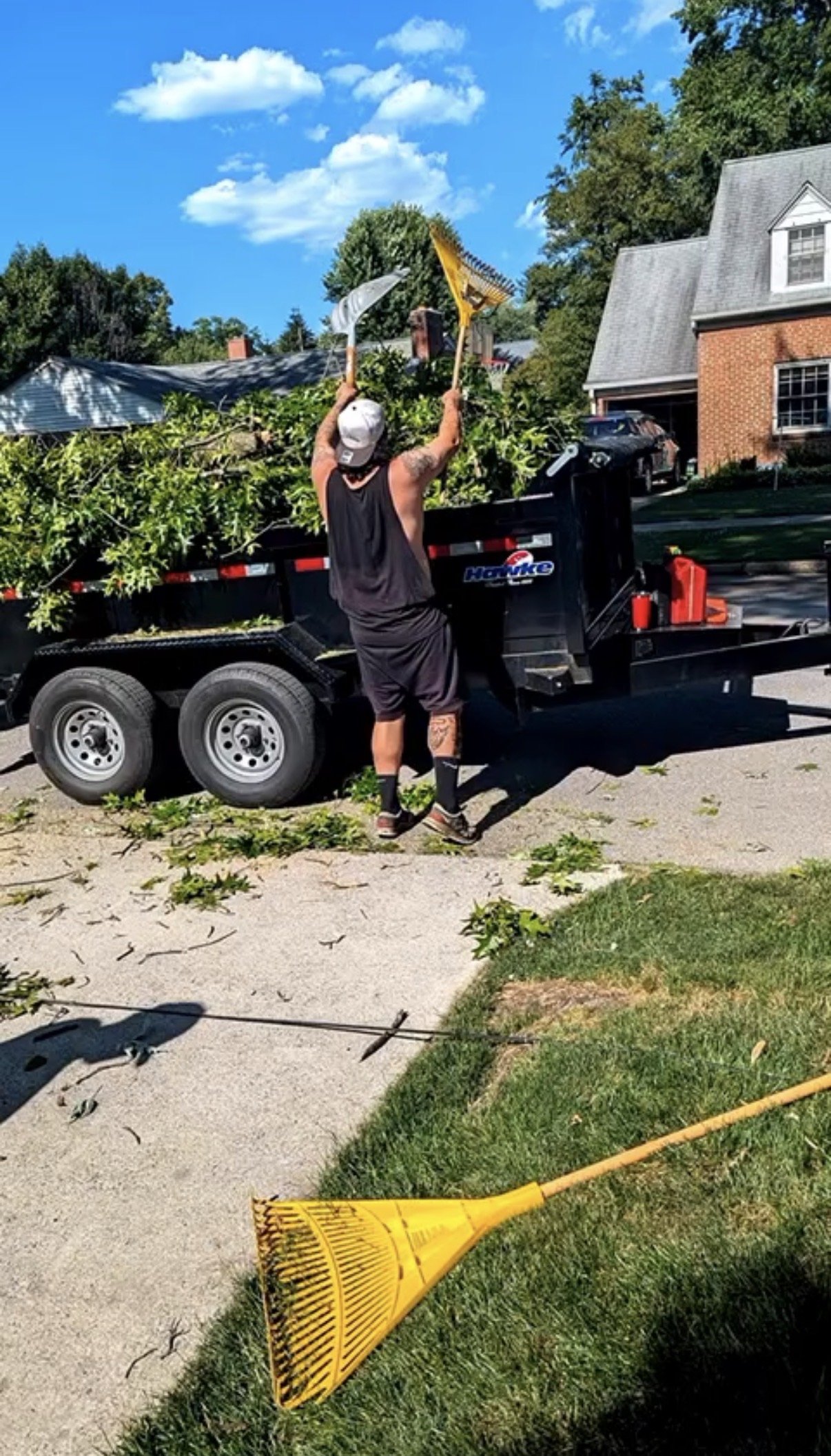 Crew loading tree branches and debris into trailer after tree trimming service in Harrisburg, PA