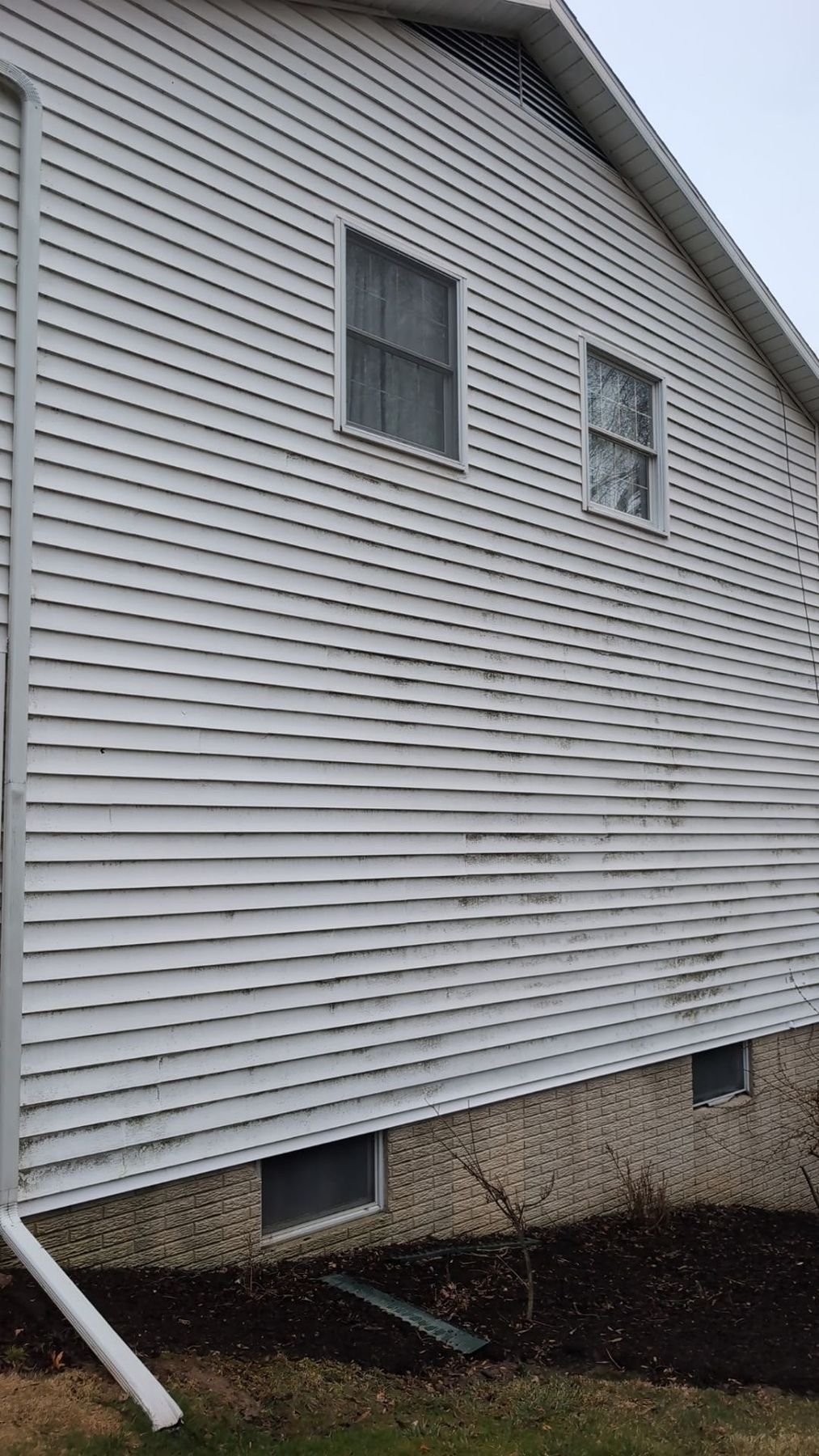 White house siding with visible dirt, algae, and buildup before professional power washing service in Central Pennsylvania