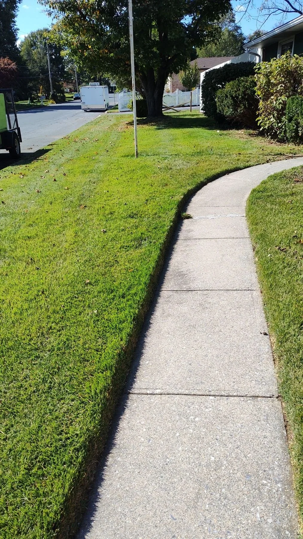 Professional lawn edging along sidewalk in Harrisburg PA showing clean sharp landscape lines