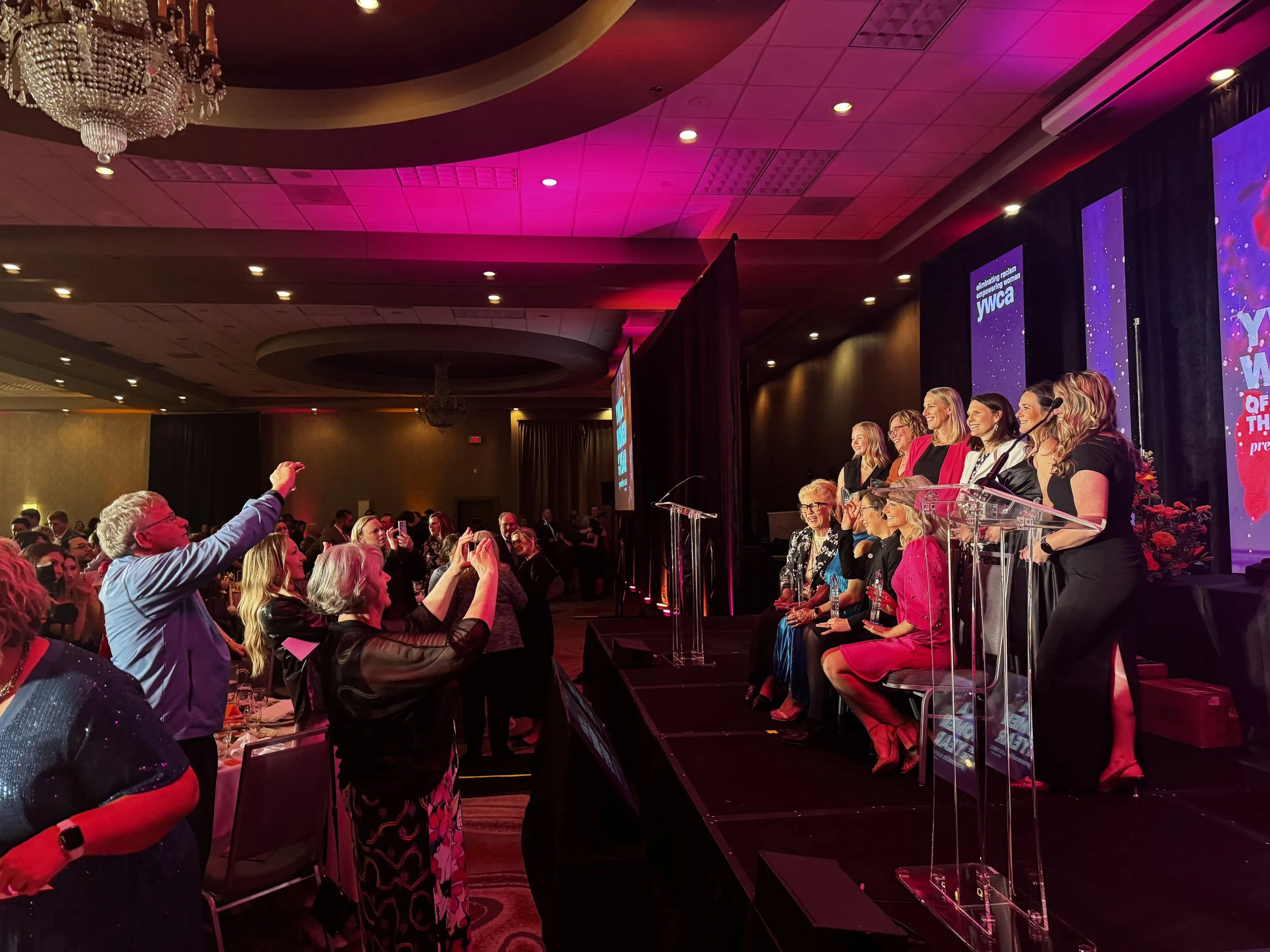 Group of women on stage posing for photograph