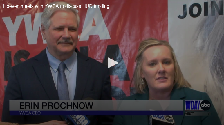 man and woman standing next to each other with news microphones