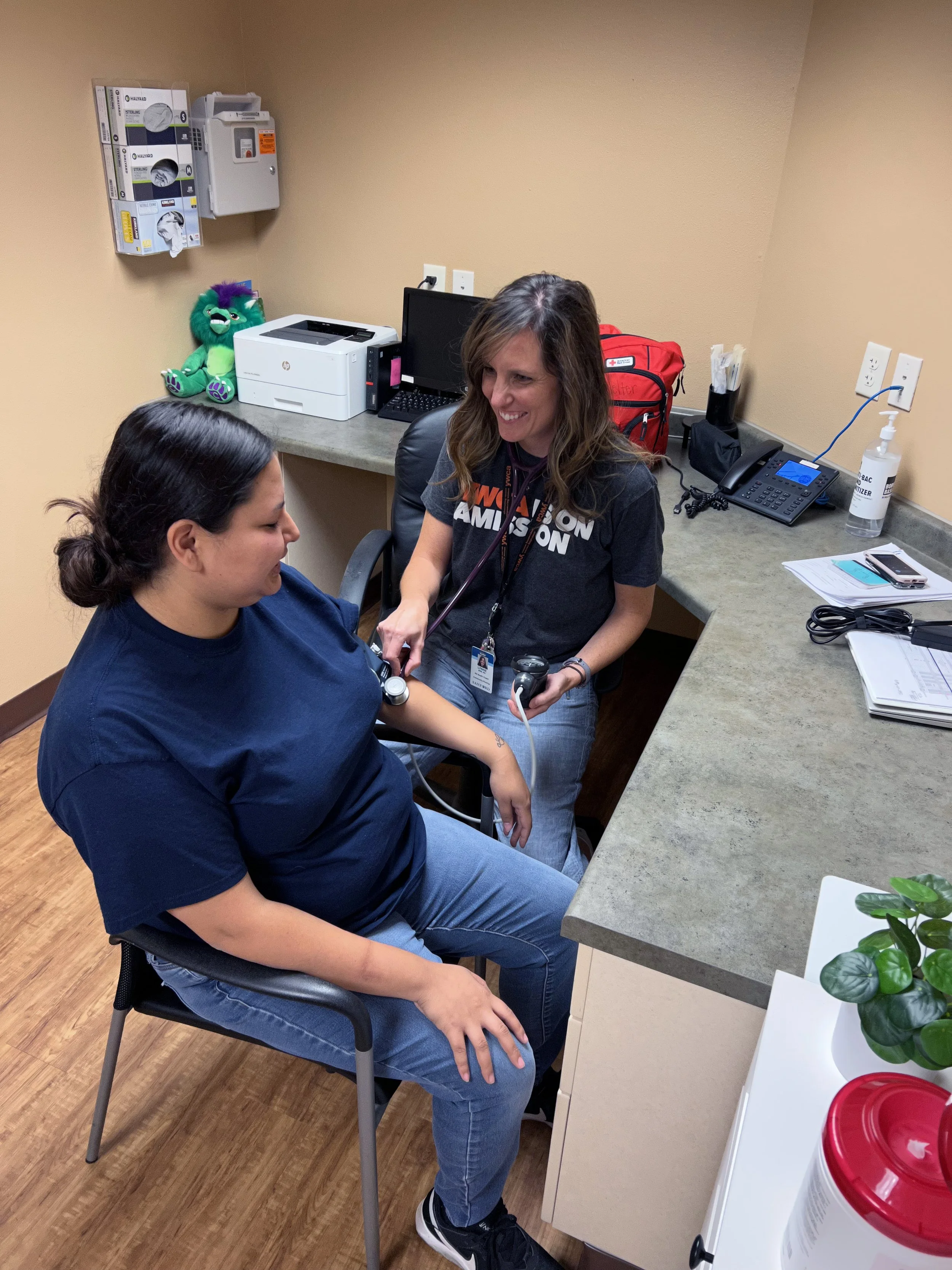 Female nurse listening to pulse of woman