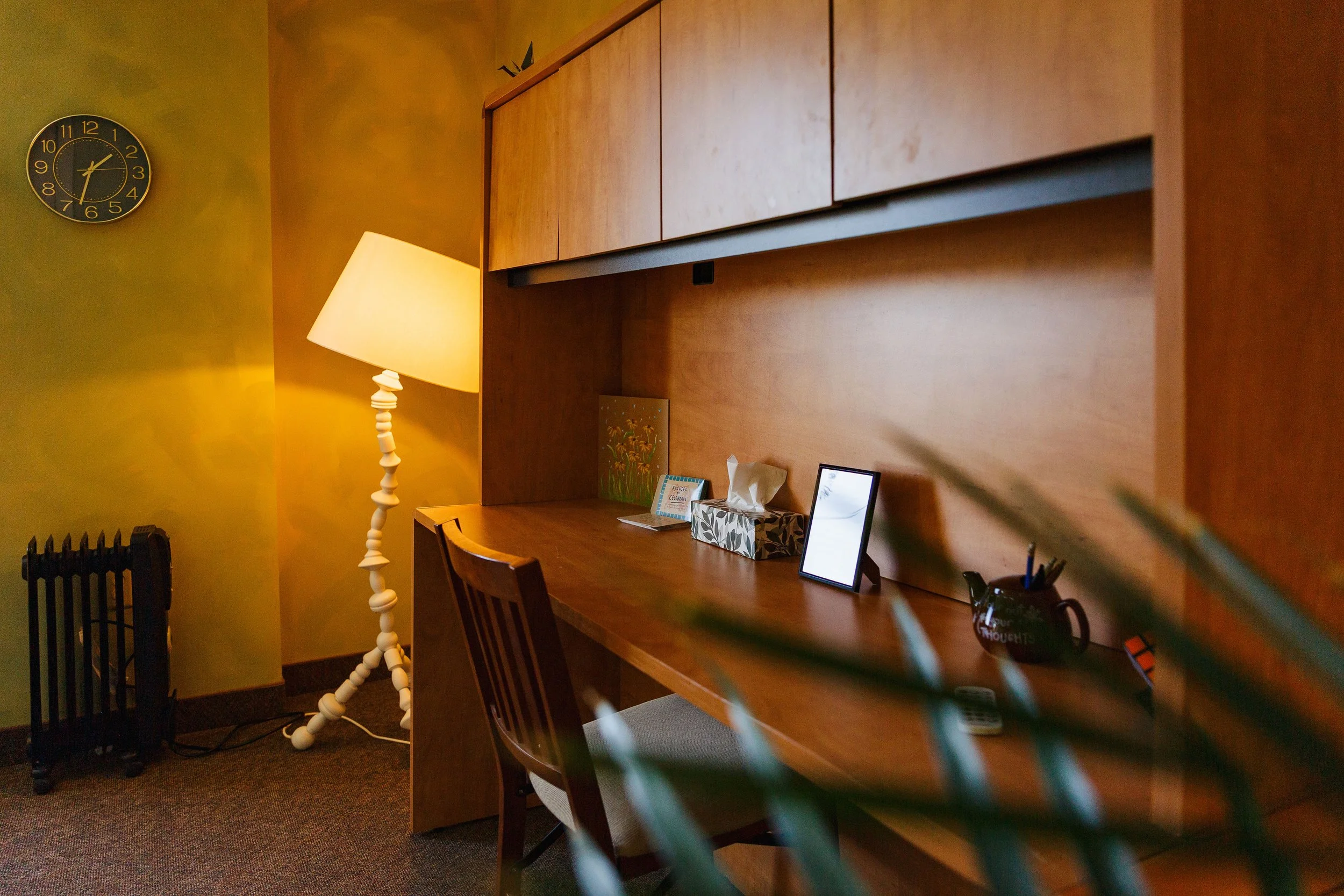 Calm, welcoming therapy room with a desk and warm lamp at Vital Mind Psychology in Cochrane, Alberta