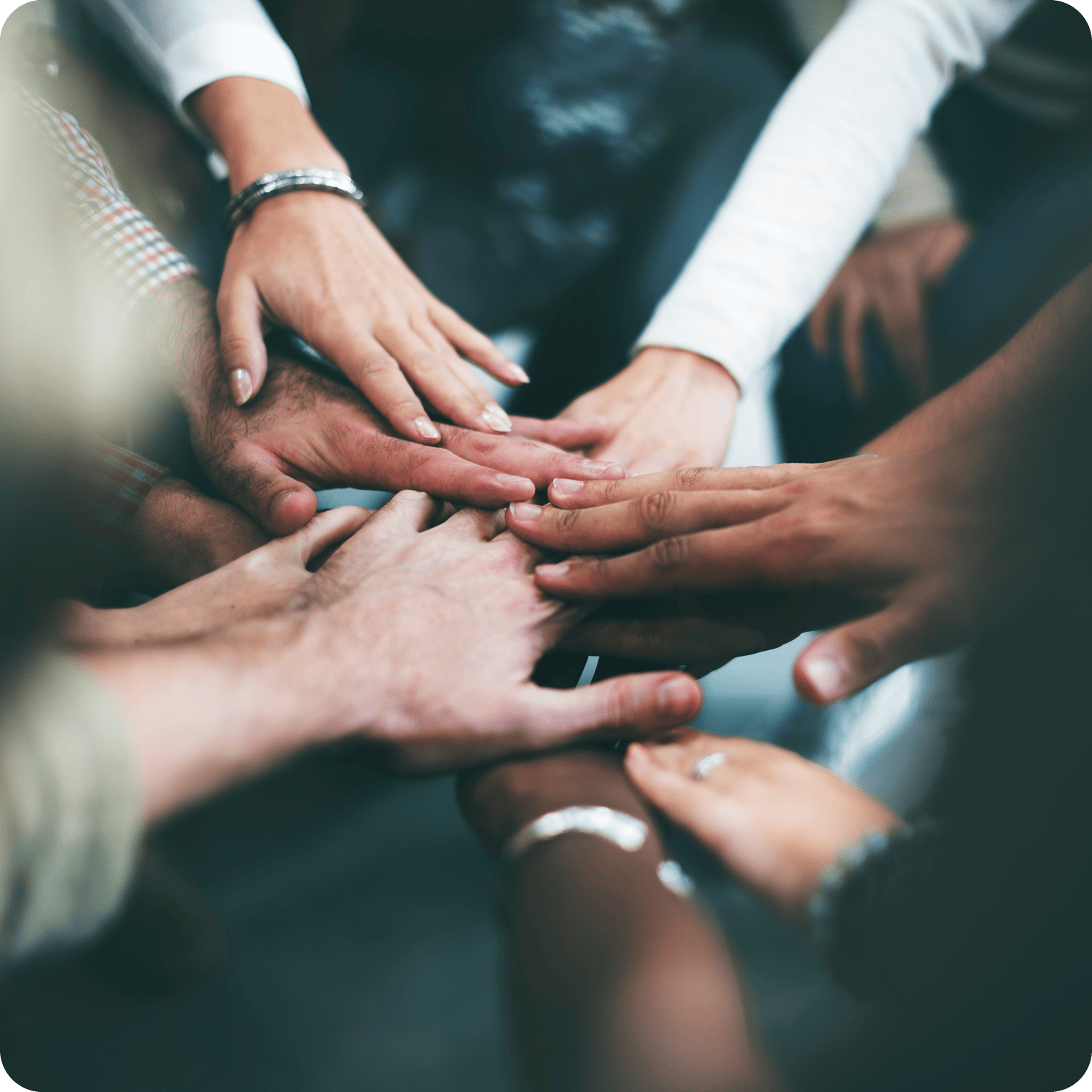 AWE team collaboration shown through group of hands stacked together