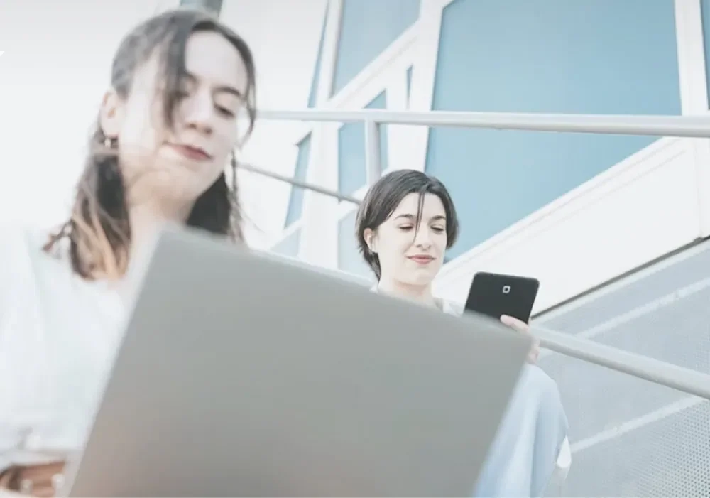 two women using digital devices preparing to take action on business plan