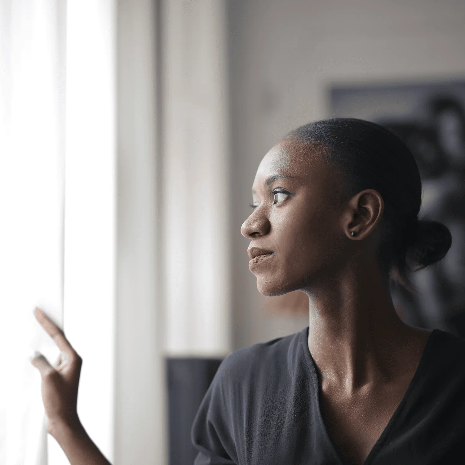 woman looking out window reflecting on next stage of business leadership