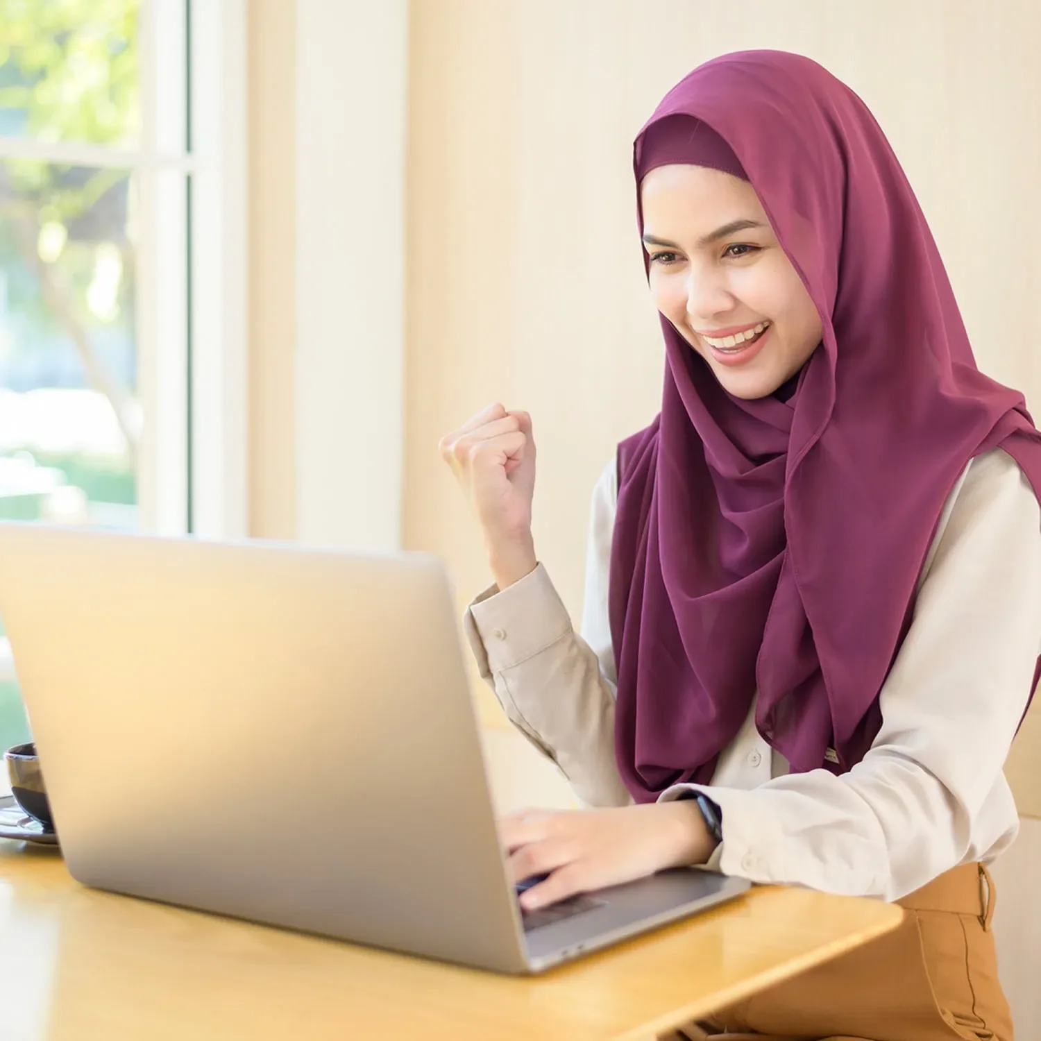 woman celebrating success behind laptop showing impact of partnerships