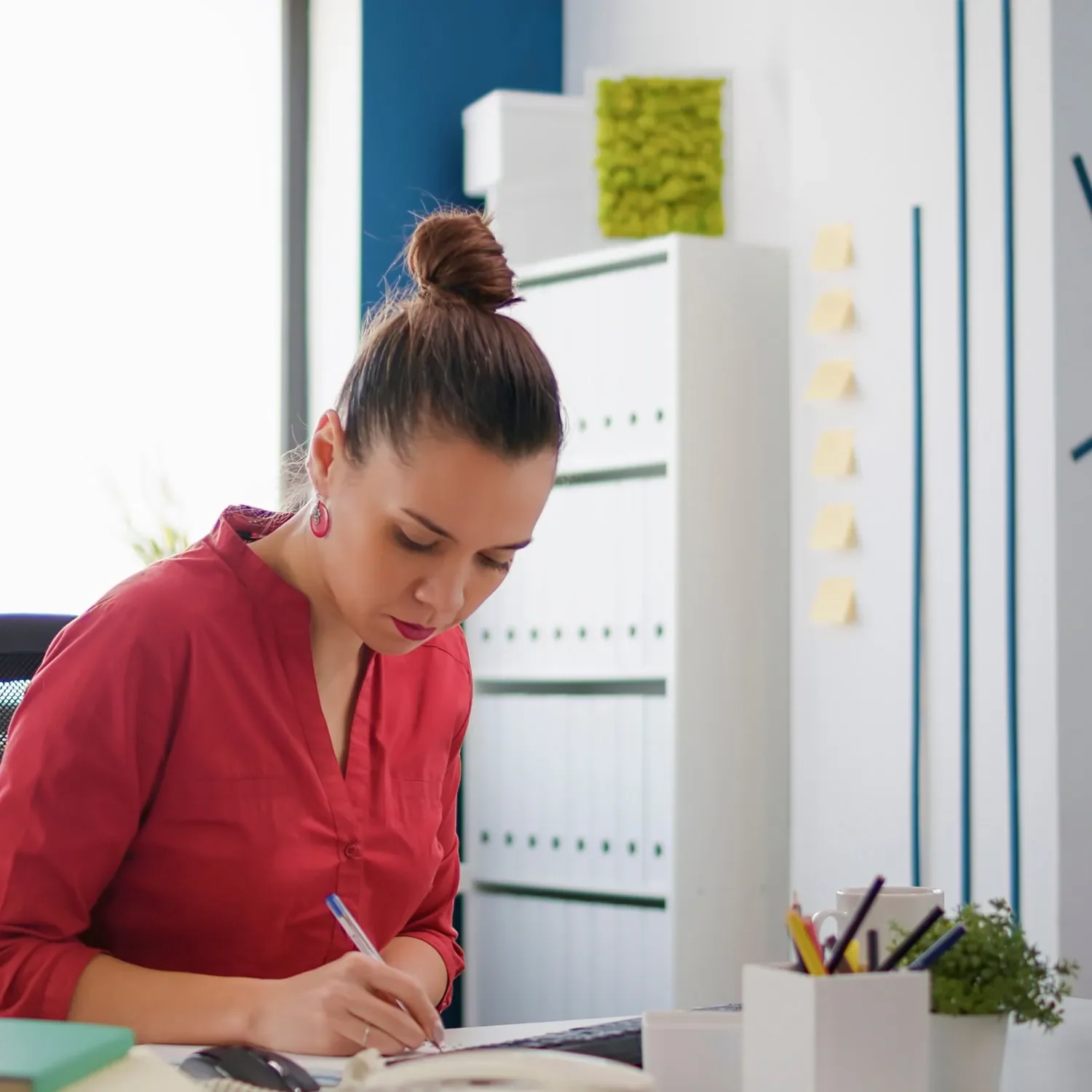 woman writing notes while planning business growth strategy