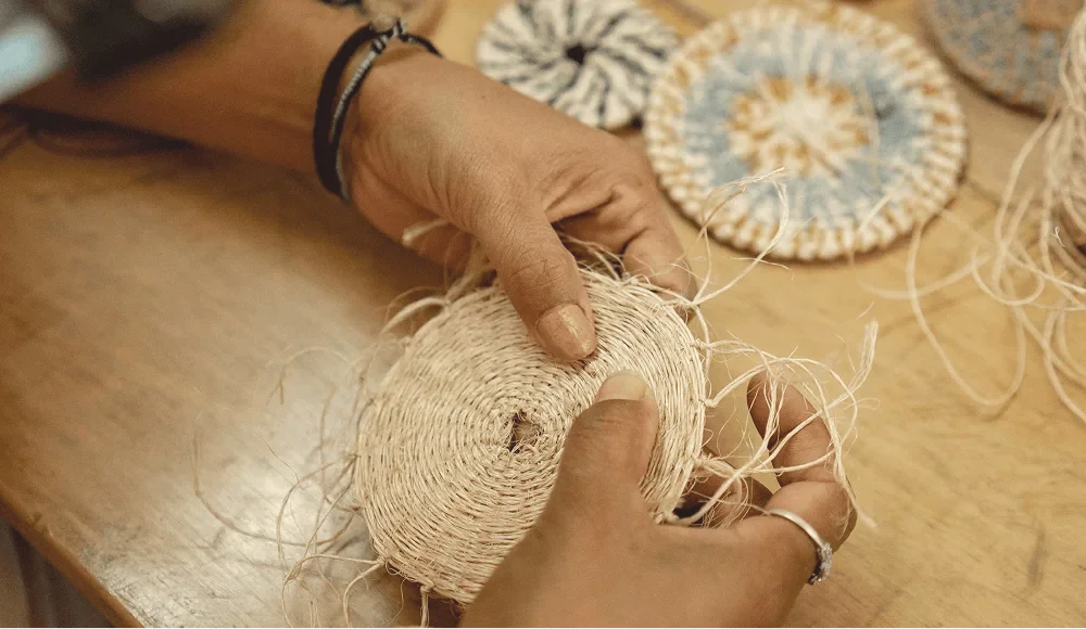 hands weaving materials representing culturally grounded learning and lived experience