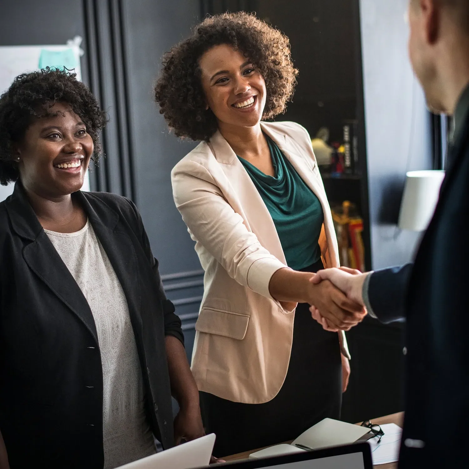 women shaking hands while finalizing business financing agreement