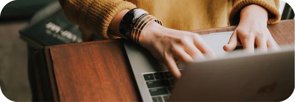 Close-up of hands typing on a laptop