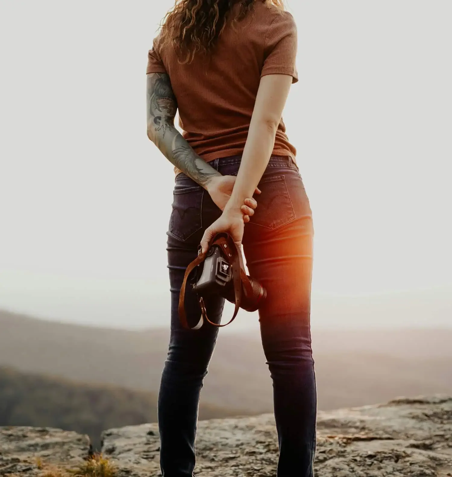 woman holding camera behind her back representing entrepreneur supported by business funding
