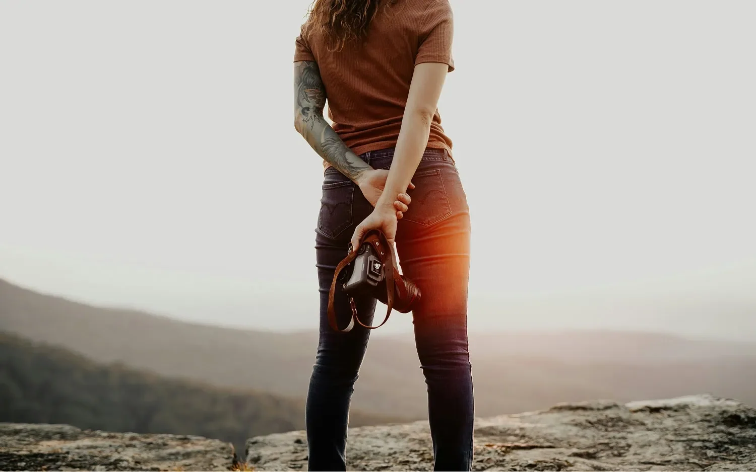 woman standing on mountain top representing business program for achieving growth goals