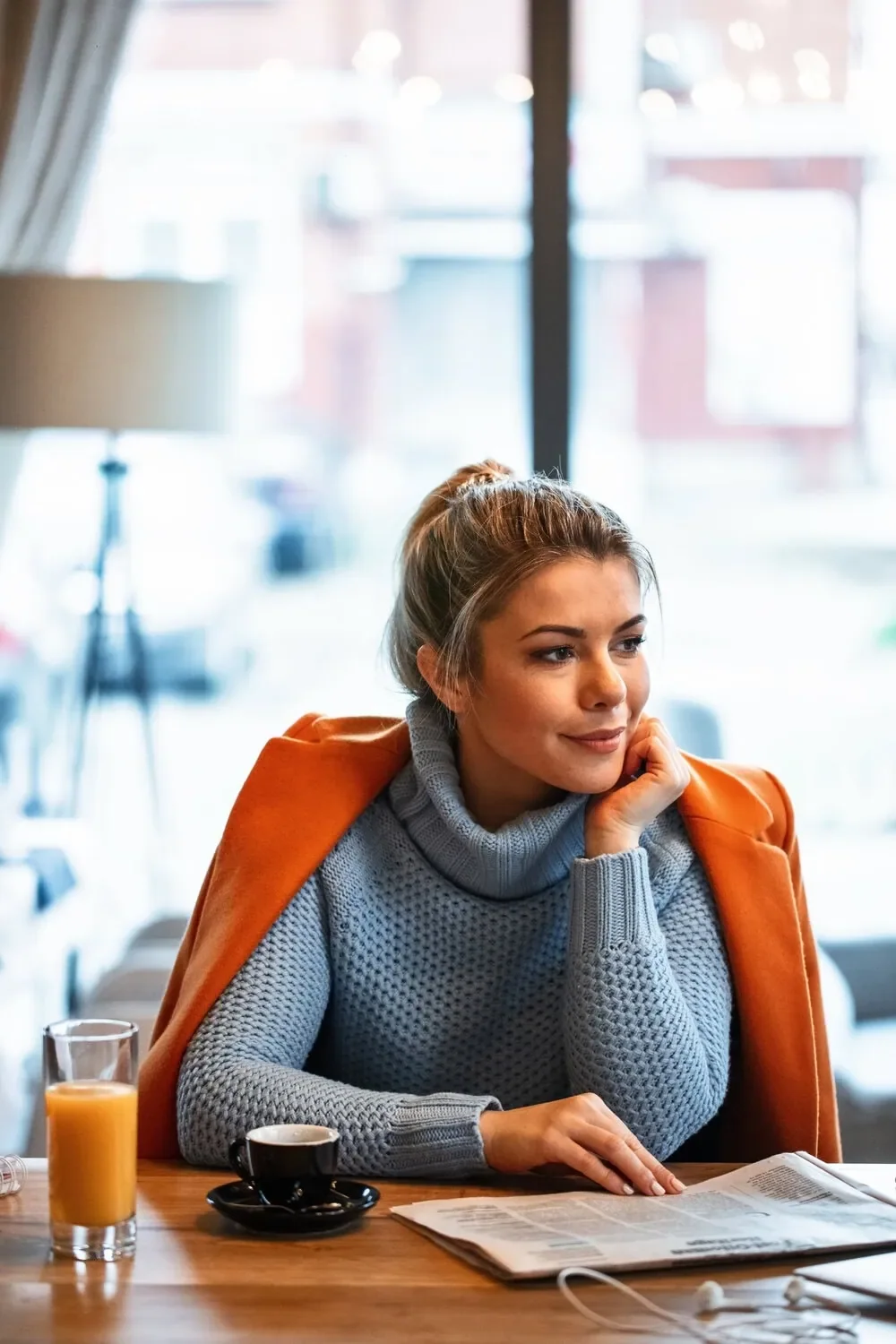 Alberta women entrepreneur reflecting on business journey while sitting in cafe with coffee