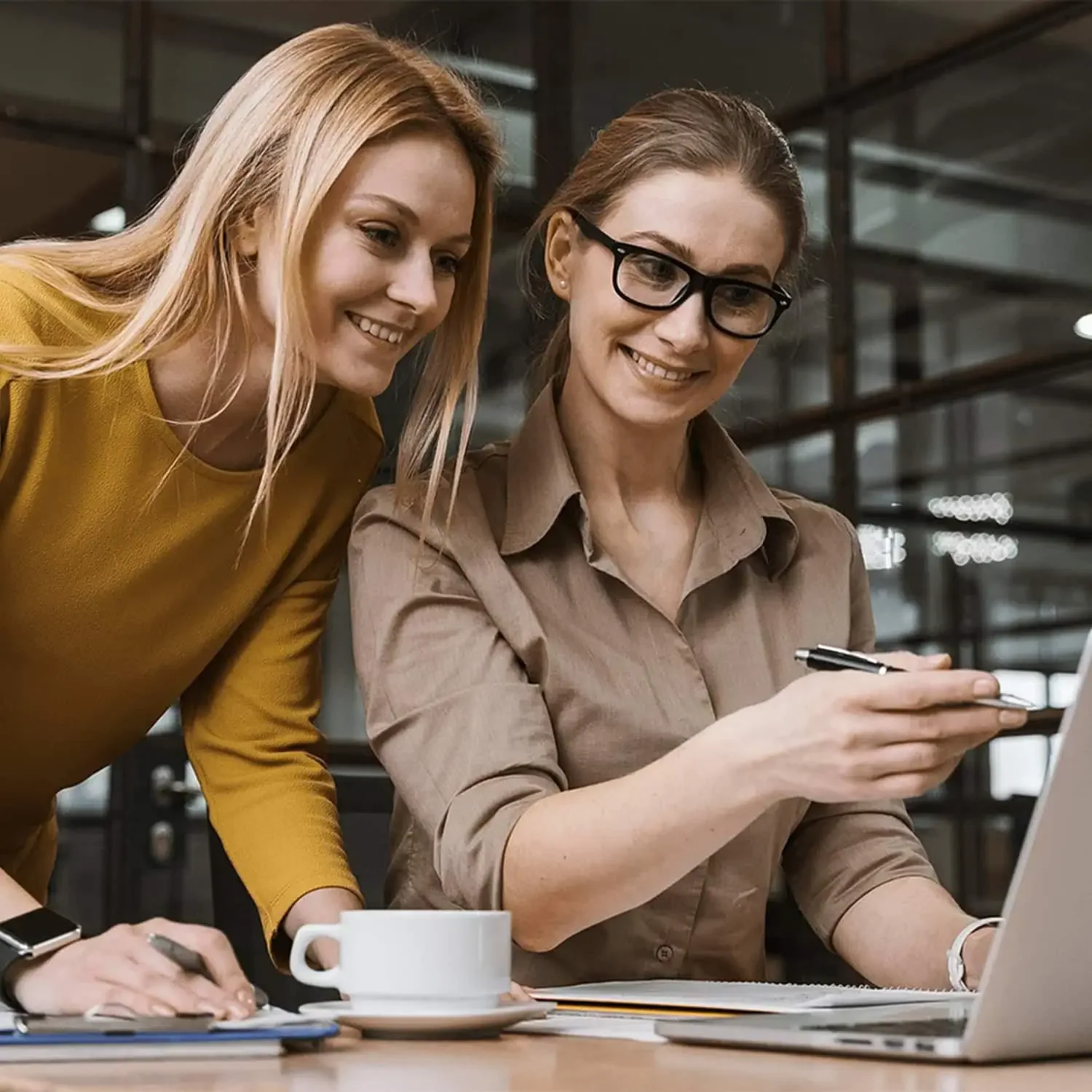 Two women reviewing laptop together as partners investing in women entrepreneurs
