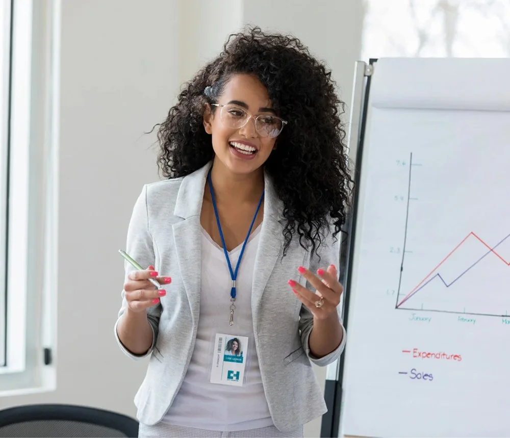 woman standing next to presentation board discussing business strategy