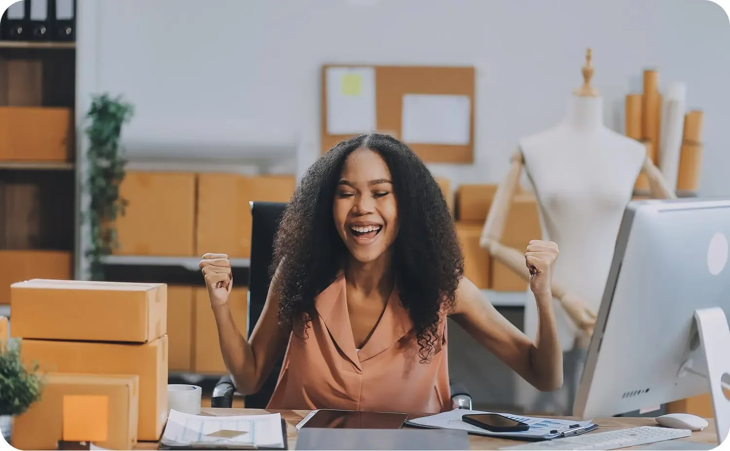 young woman at desk surrounded by orders running her small business