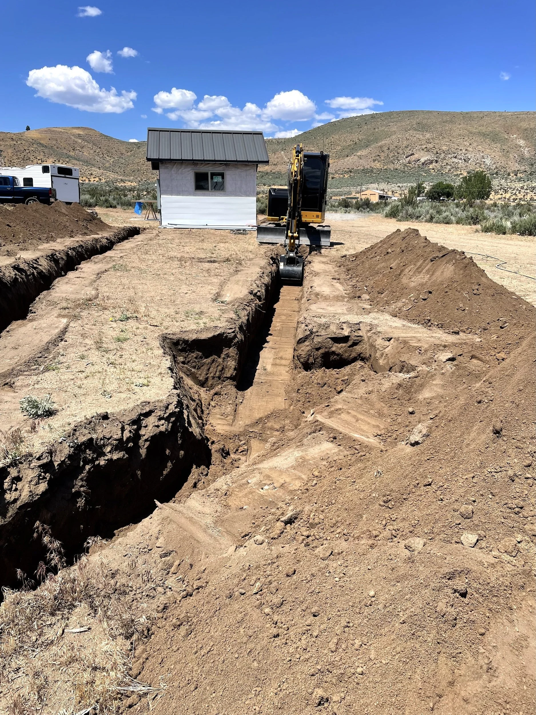 Deep trench excavated toward a homesite under construction