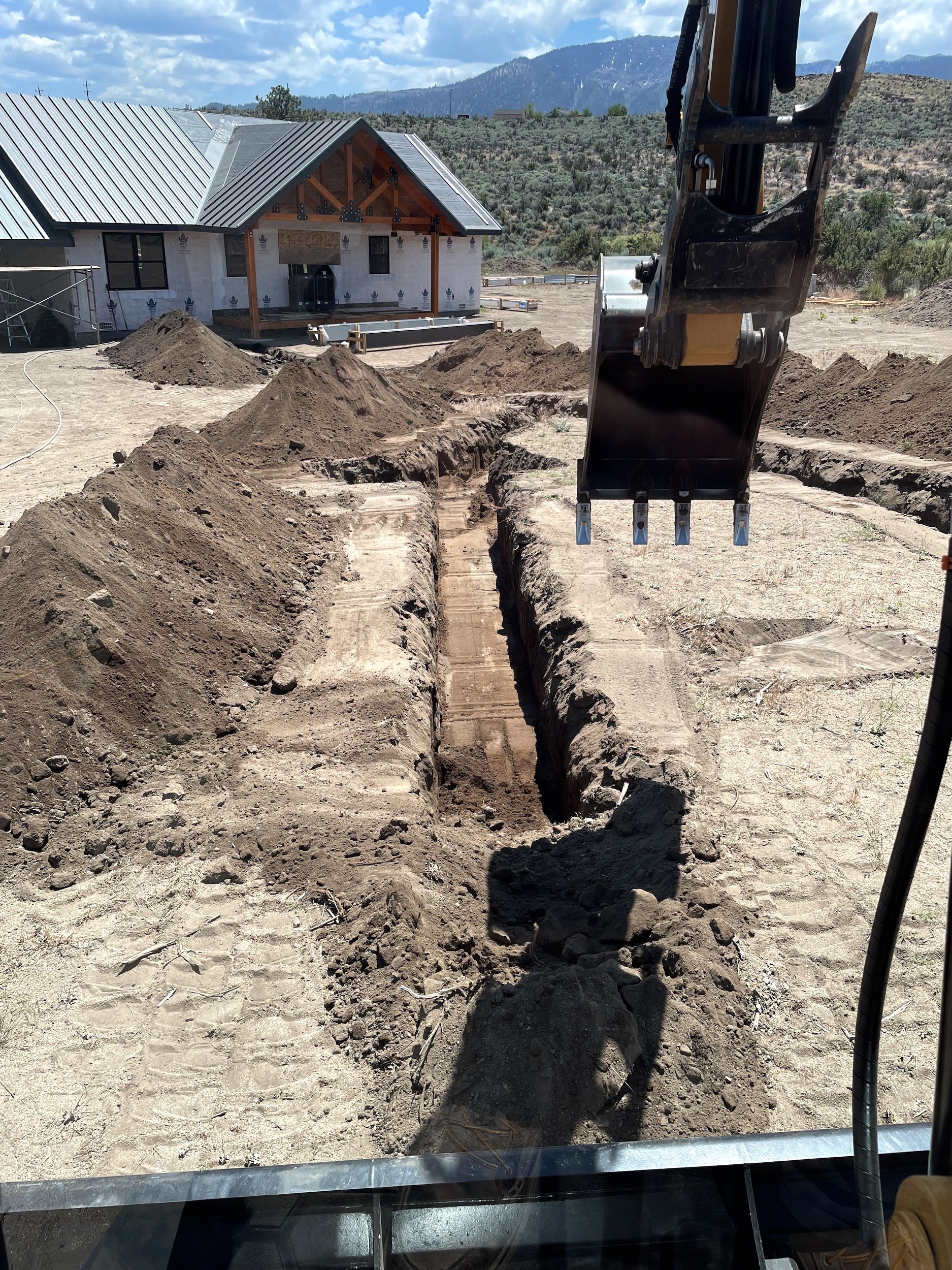 Deep trench excavated toward a homesite under construction