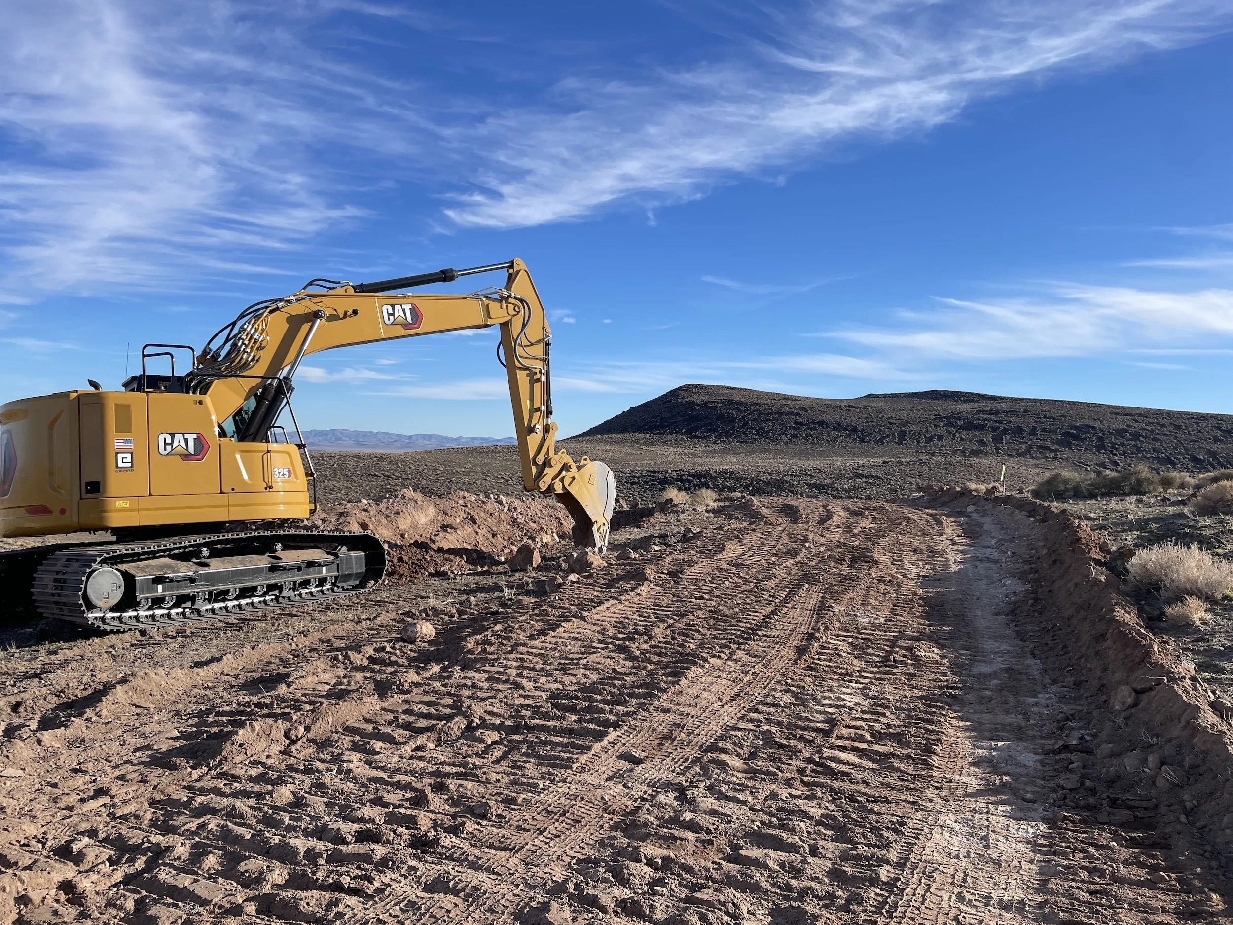 Excavator on a graded dirt road in Northern Nevada