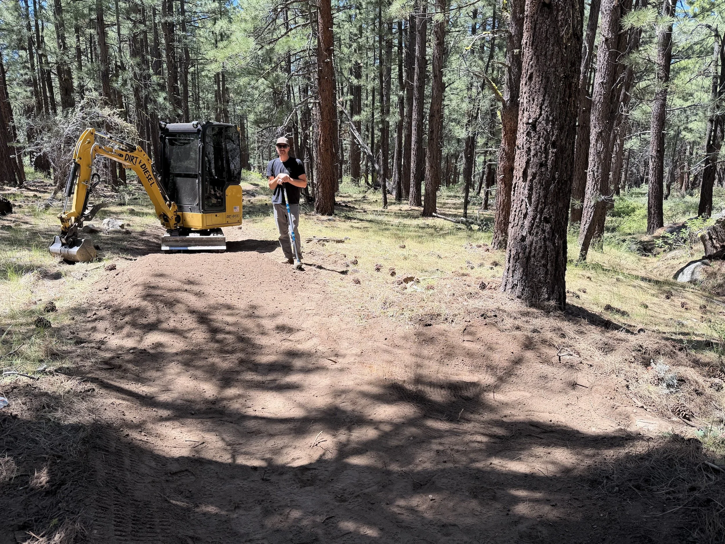 Excavator and crew member on a trail in a Northern Nevada pine forest