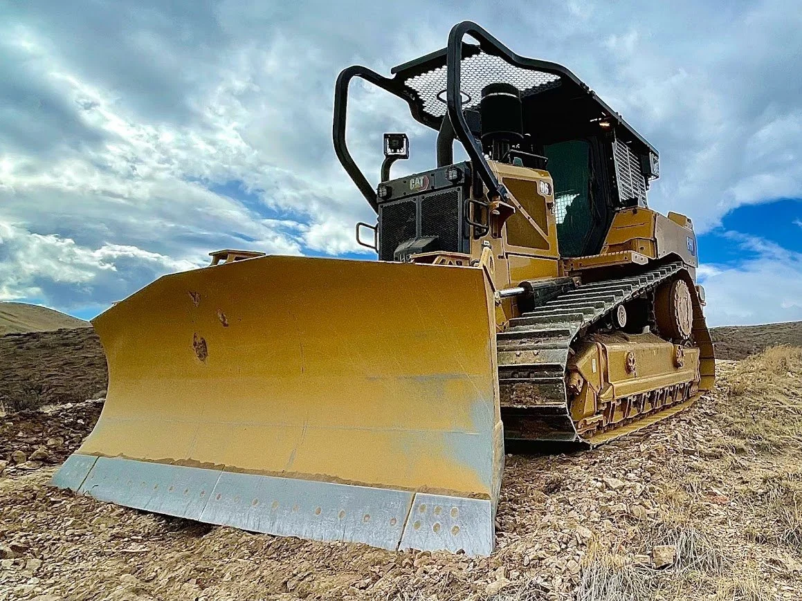 Bulldozer on a rocky hillside under a cloudy sky in Northern Nevada