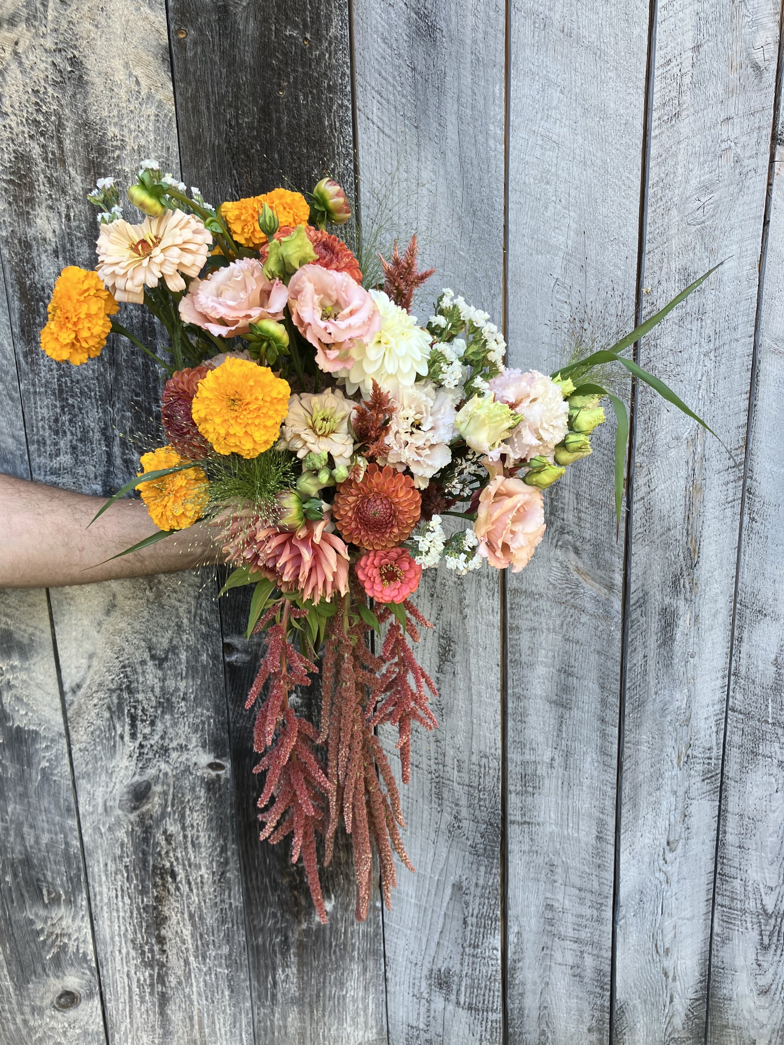 A cascading bridal bouquet features dahlias and lisianthus, which look like romantic garden roses. 