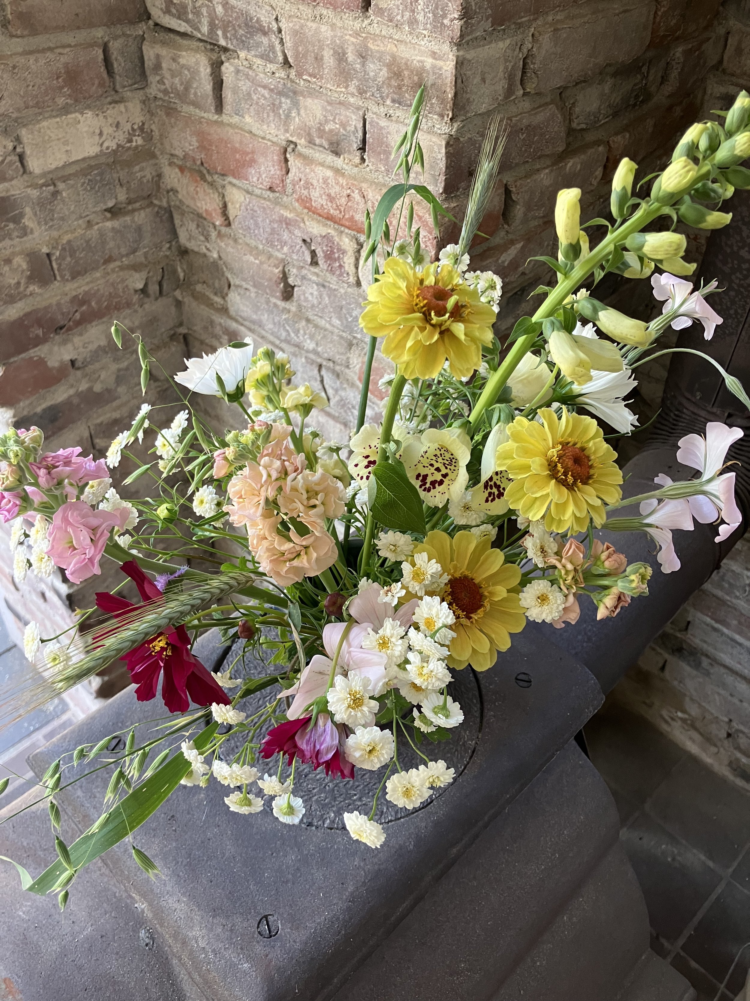A centerpiece arrangement has a pastel color story with a touch of wine. 