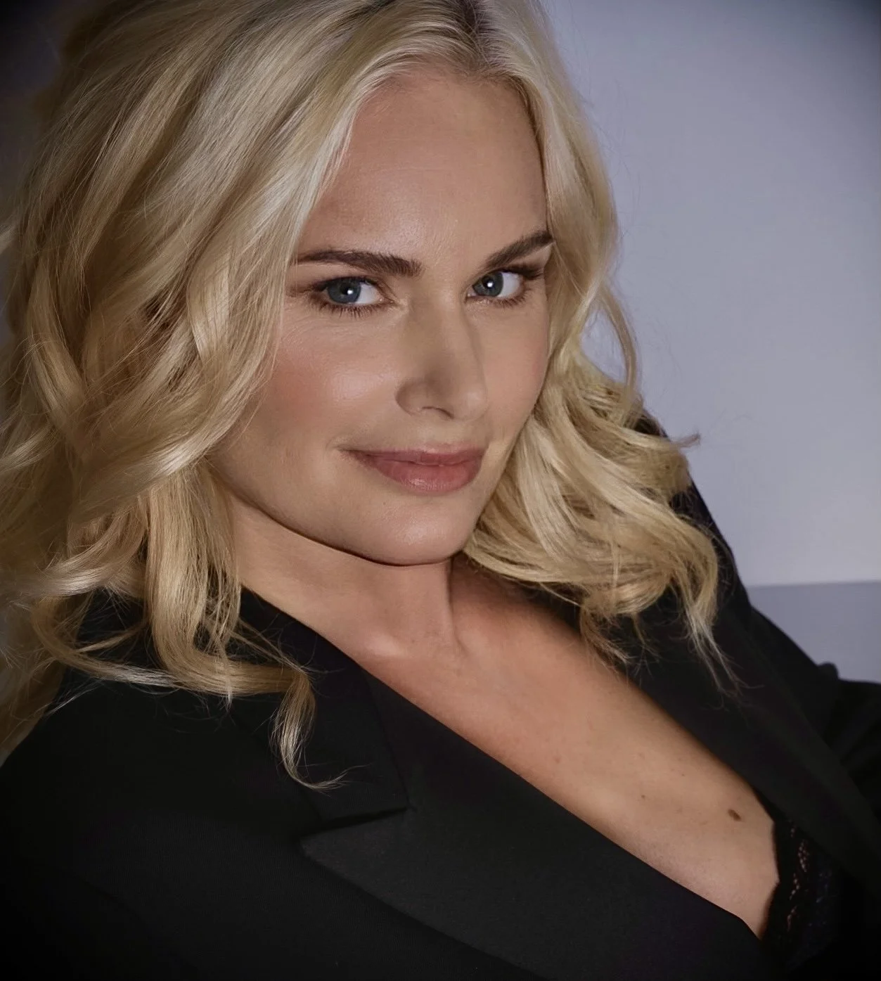 Portrait of a woman with blonde hair and a black blazer.