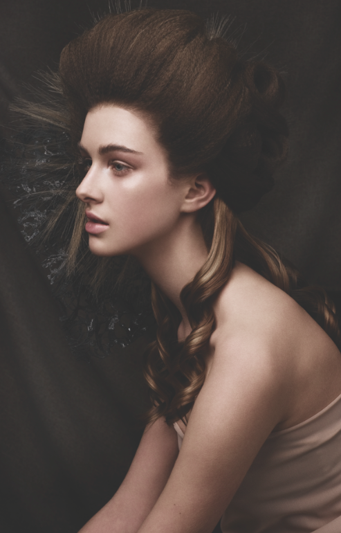 Portrait of a woman with elaborate hairstyle and dramatic lighting