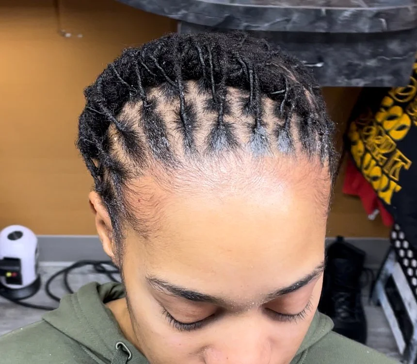 Close-up of a woman with small twisted braids in her hair, showing the top view of her scalp and hairstyle.