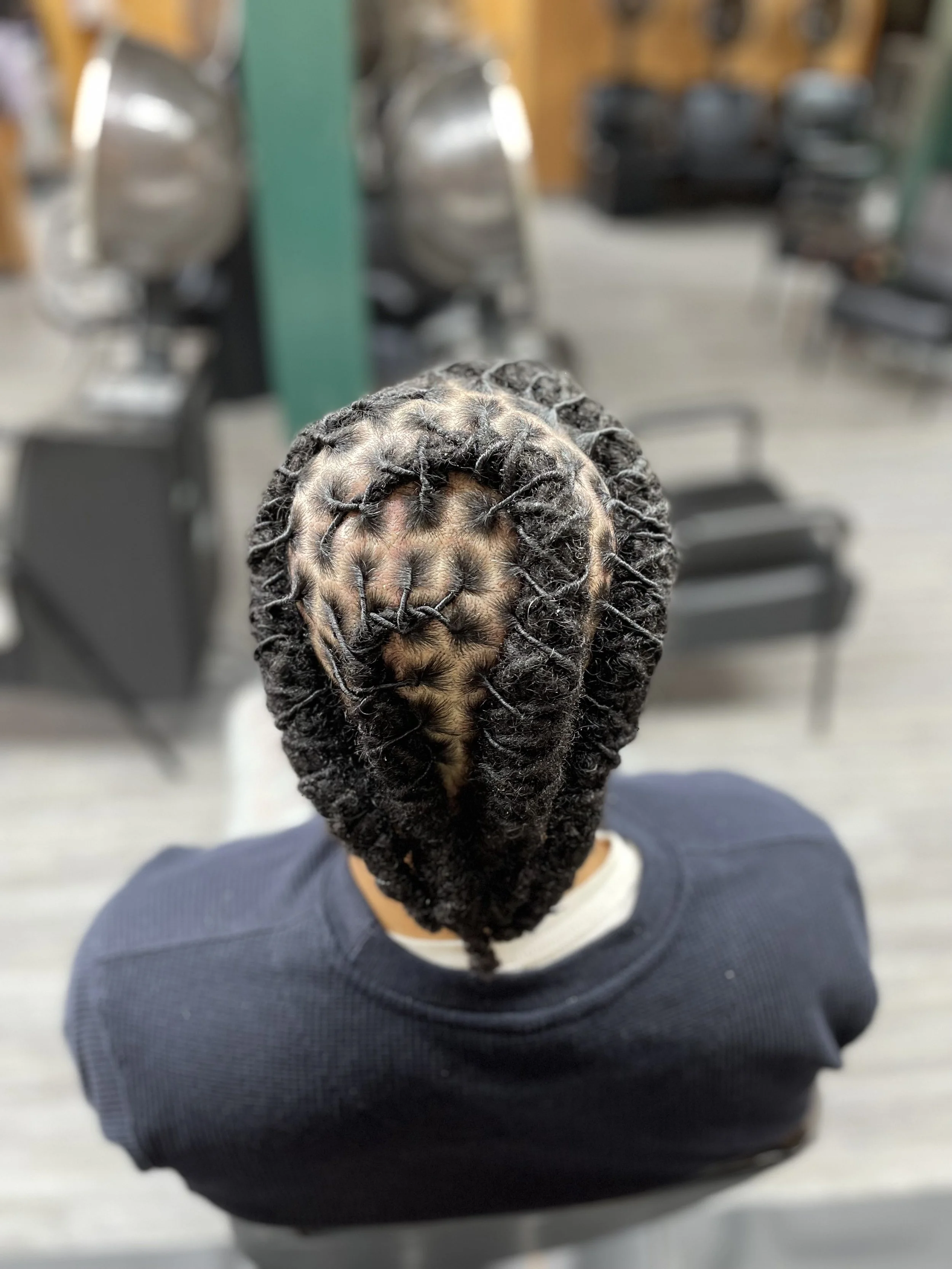 Top view of a person with freshly styled dreadlocks at a hair salon.
