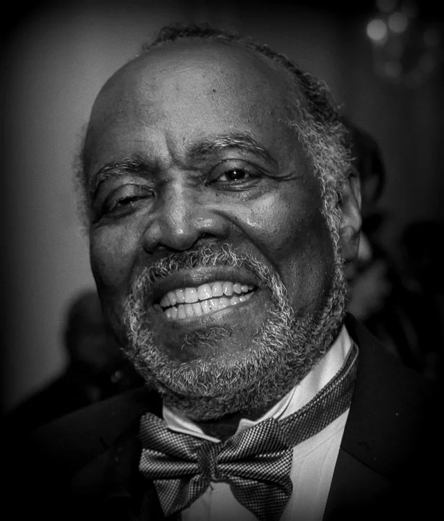 Black 7 white portrait of a smiling Black man (Joslyn N. Williams)