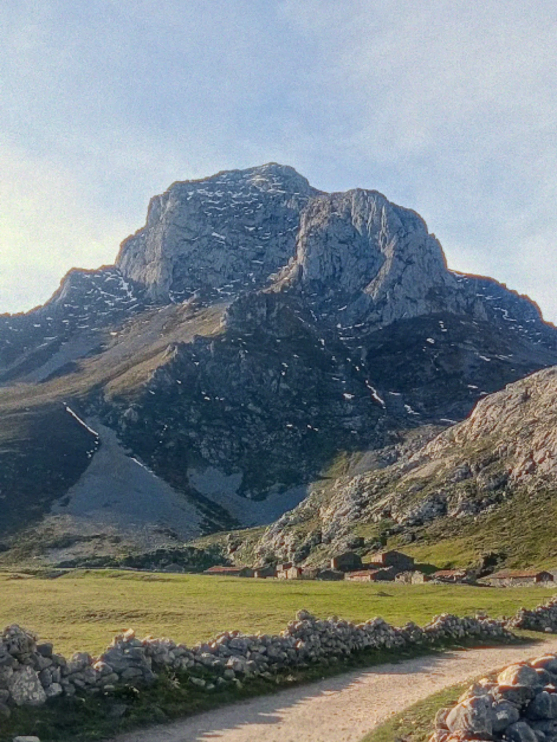 A view from the mountain valley completely surrounded by colossal, towering peaks at Vegas de Sotres