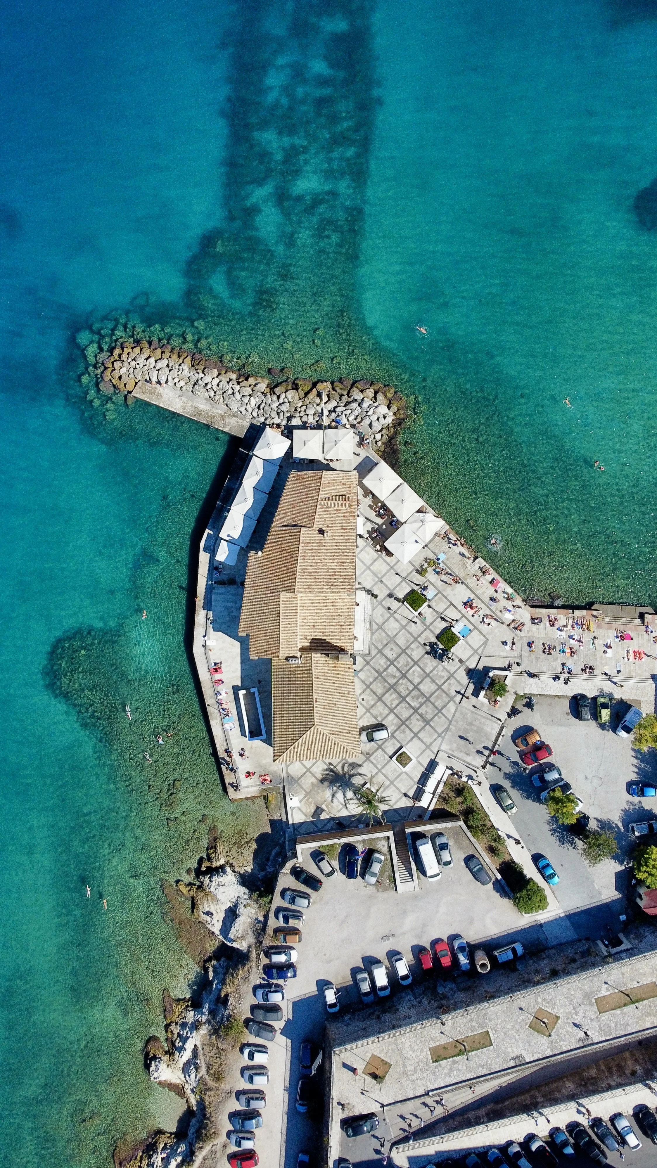 Top down ariel view over the clear sea and restaurant area at Faliraki, Corfu.