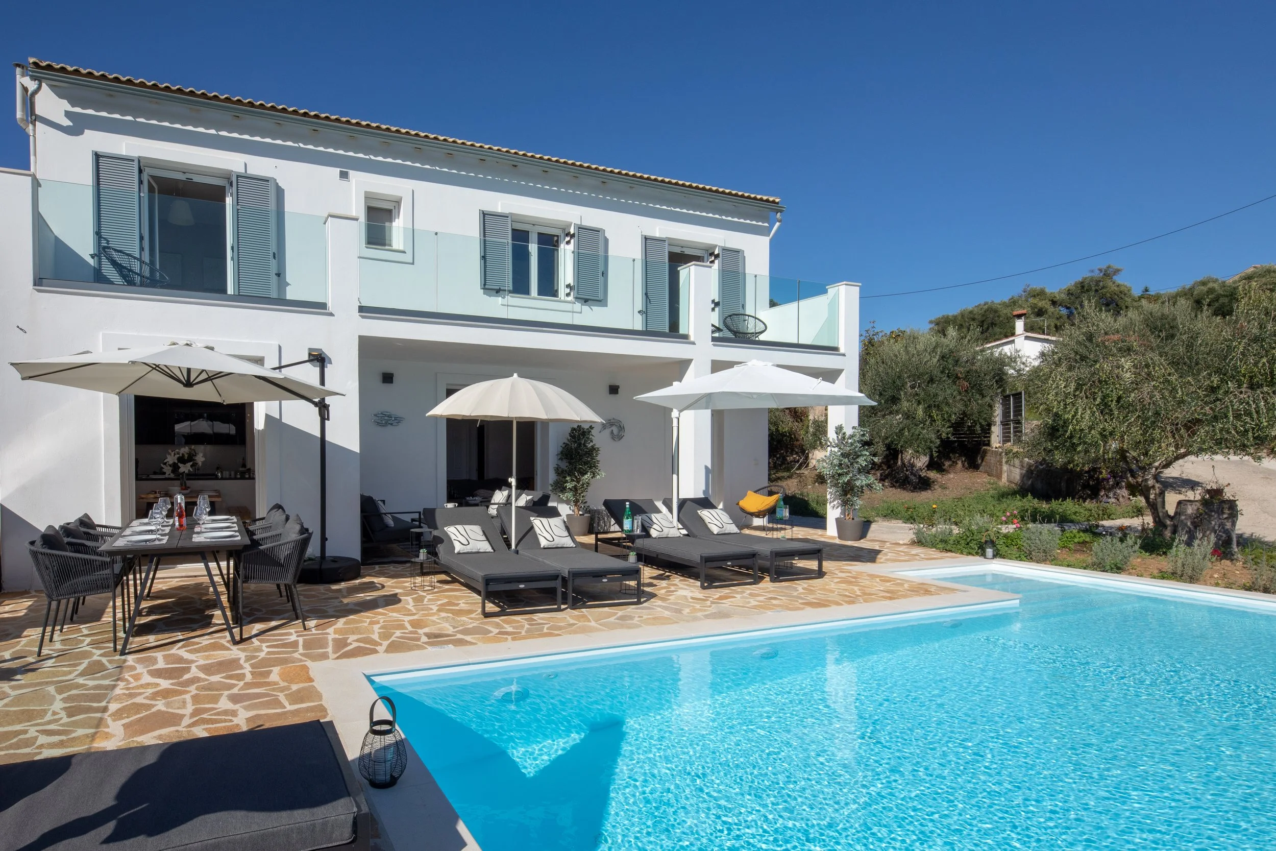 A sunny day at Villa Icarus Corfu with views towards the house across the private swimming pool.
